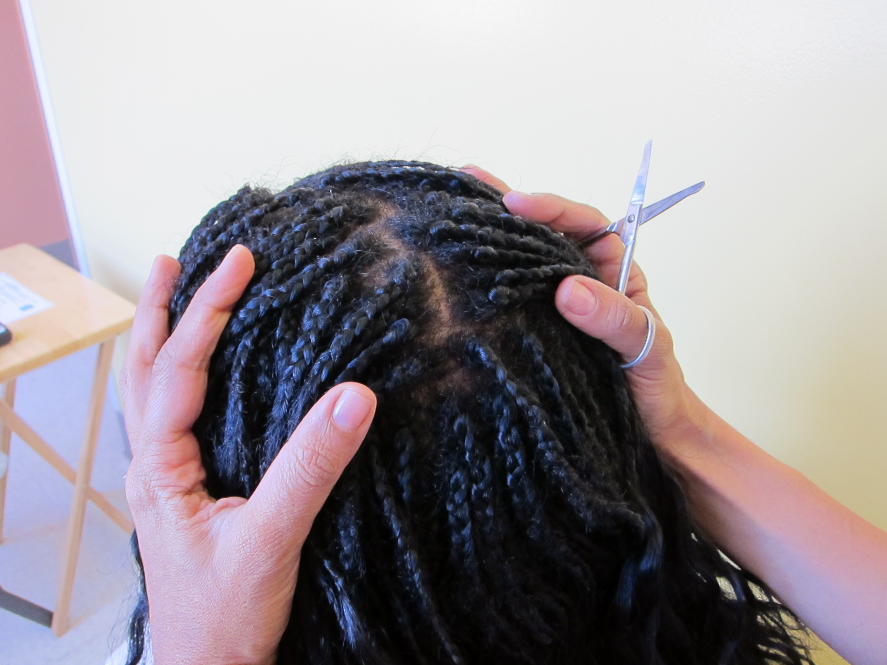 Looking at the back of a person's head at where hair braids connect to the scalp, b